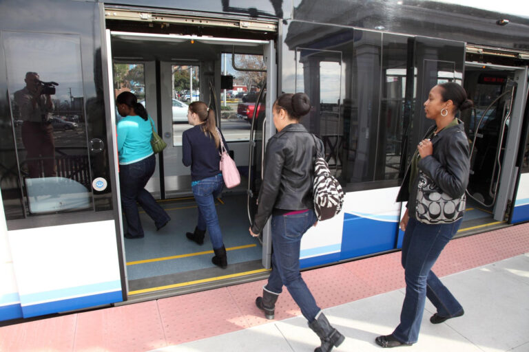 Image photographique de passagers montant à bord d'un train léger sur le système de train léger HRT Tide.